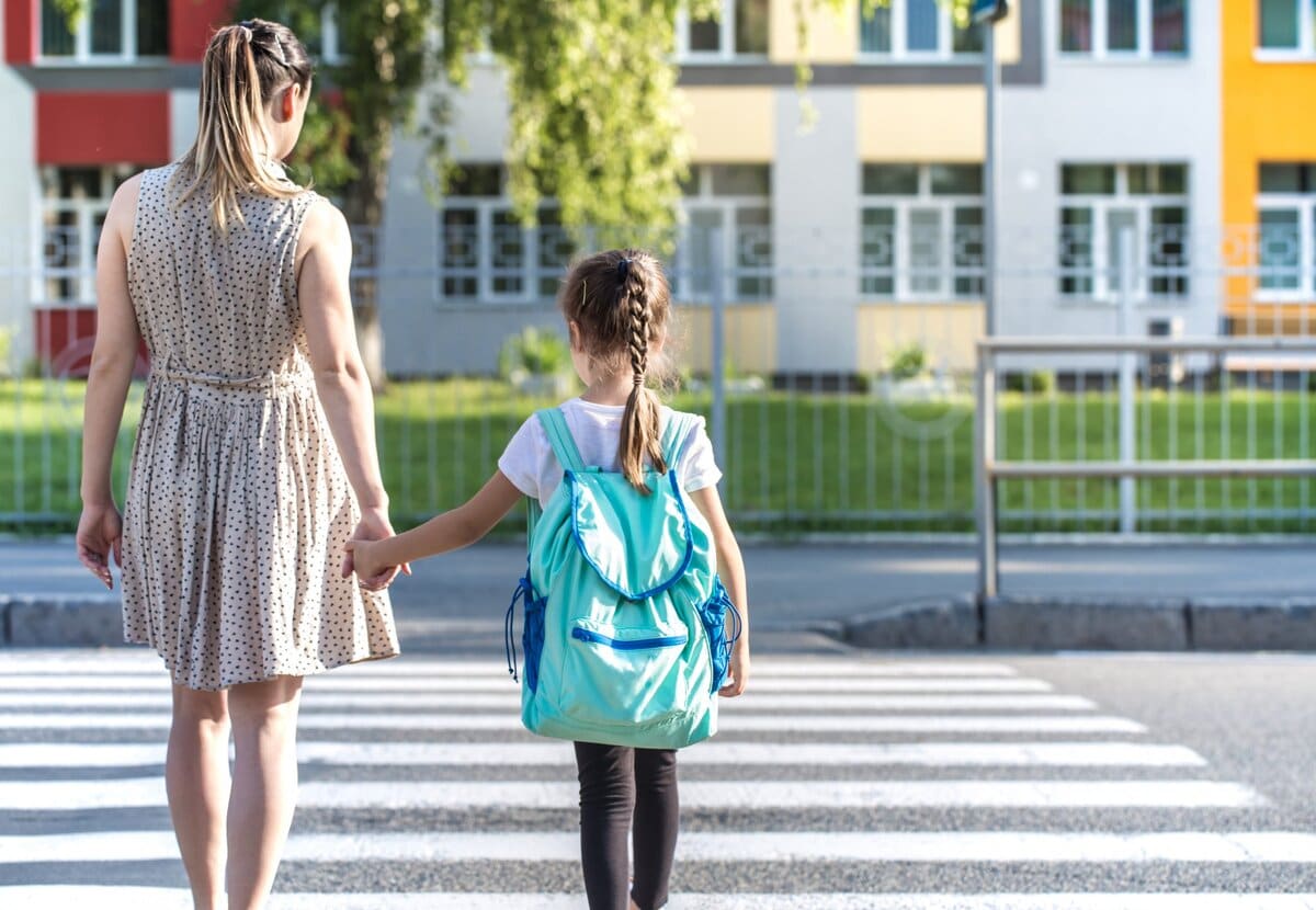 Back to school education concept with girl kids, elementary students, carrying backpacks going to class