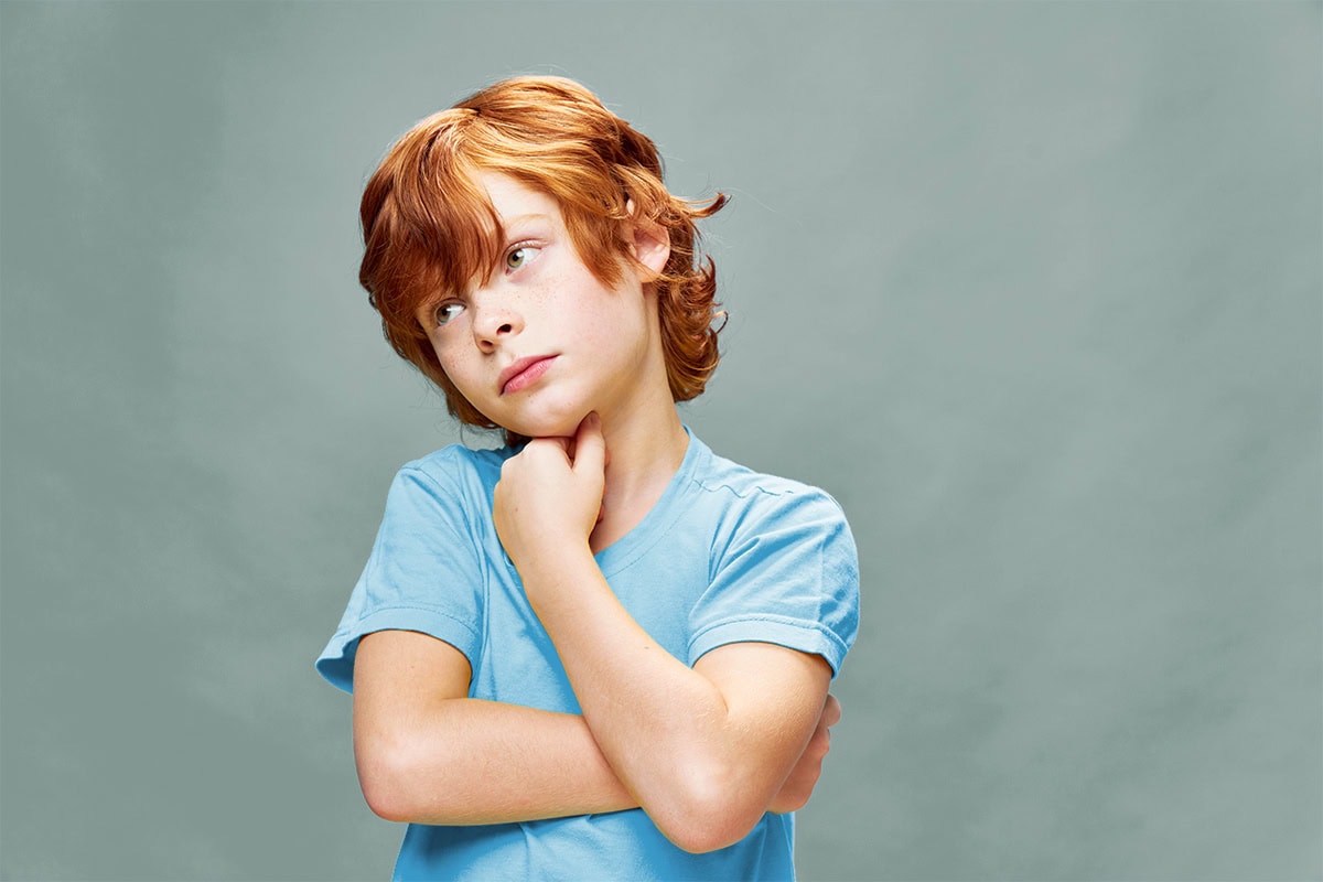 Red-haired,Boy,Looks,Away,Holds,His,Hand,Near,His,Face