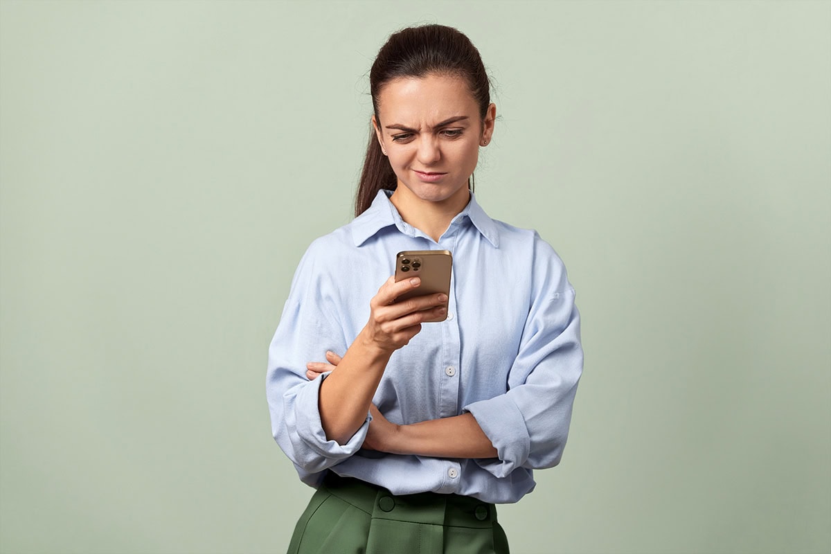 Frau guckt kritisch Frau guckt kritisch auf ihr Smartphone