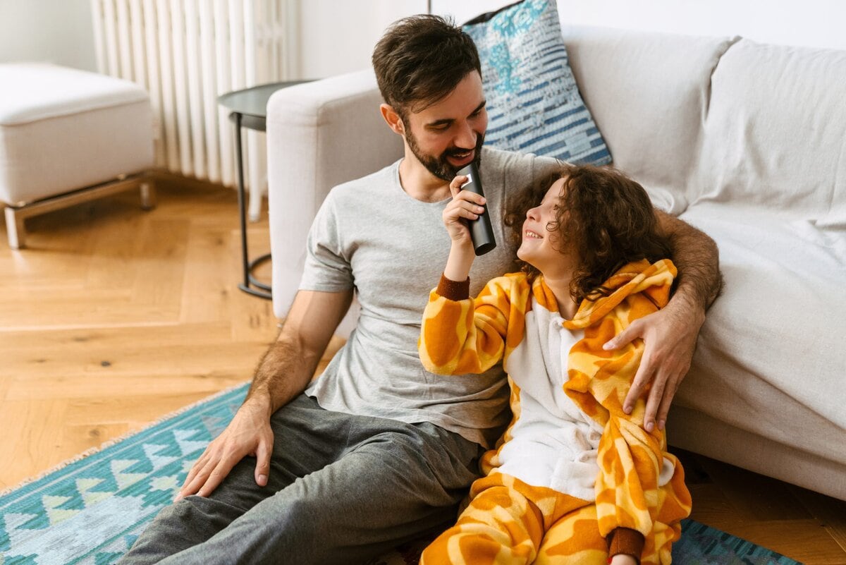 Cheerful,Father,And,Son,Watching,Tv,Together,While,Sitting,On