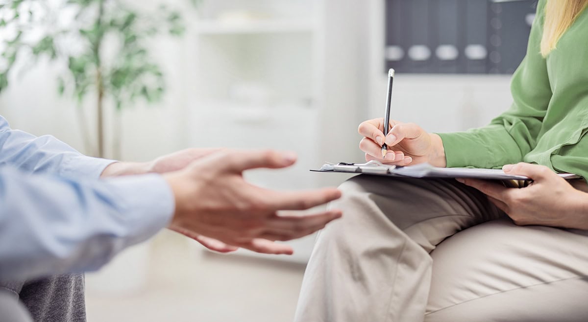 Psychologist,Woman,Doctor,Making,Notes,Consulting,Male,Patient,In,Bright